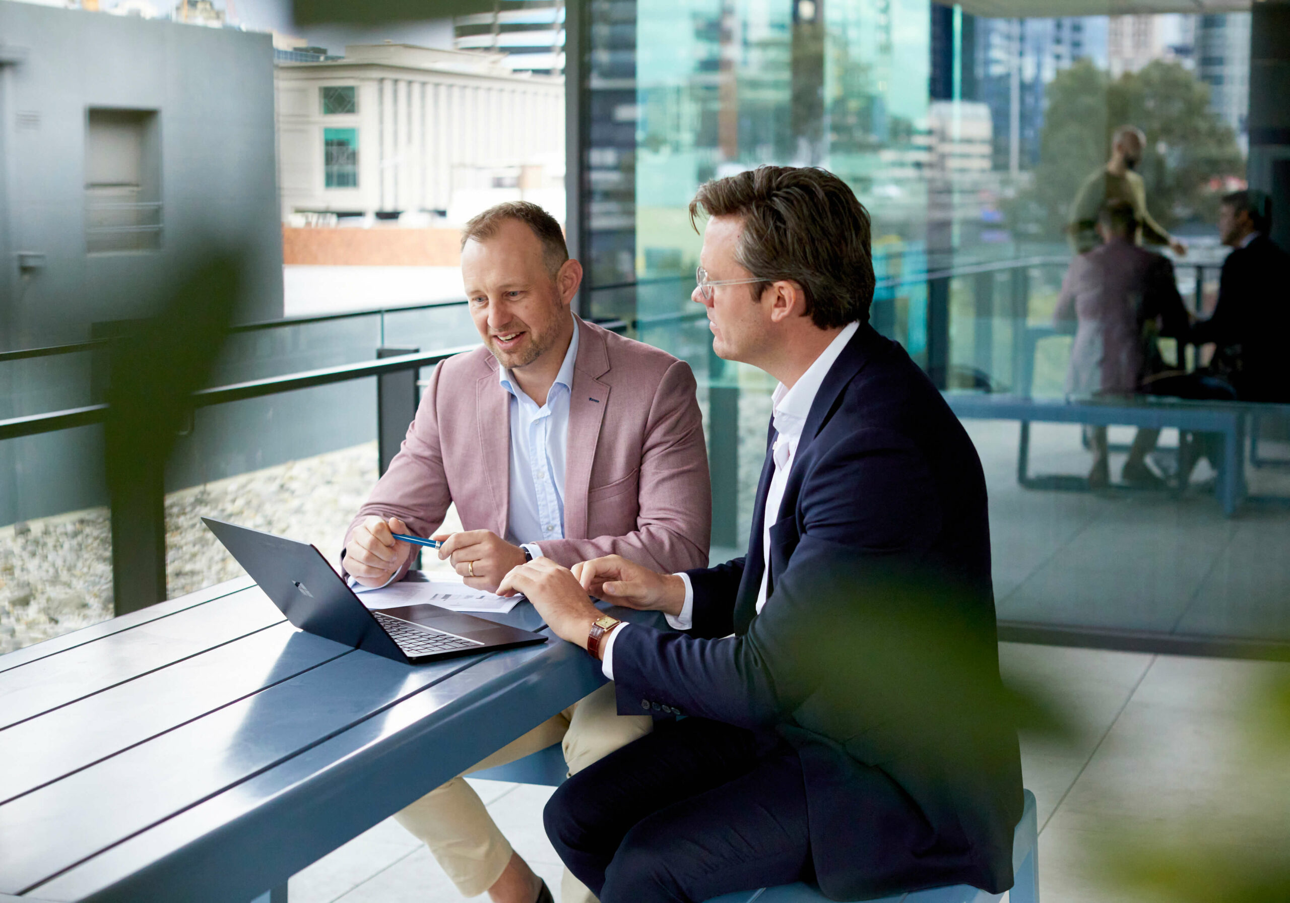 Two men in suits working together.