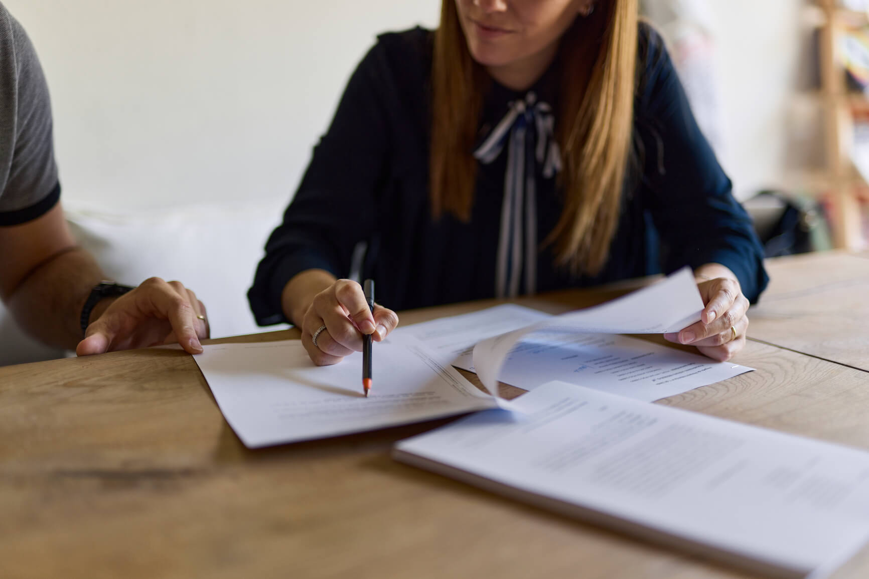 A professional woman explains documents to her client.