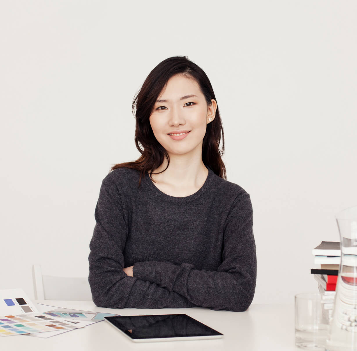 A confident woman sits across the desk from the camera.