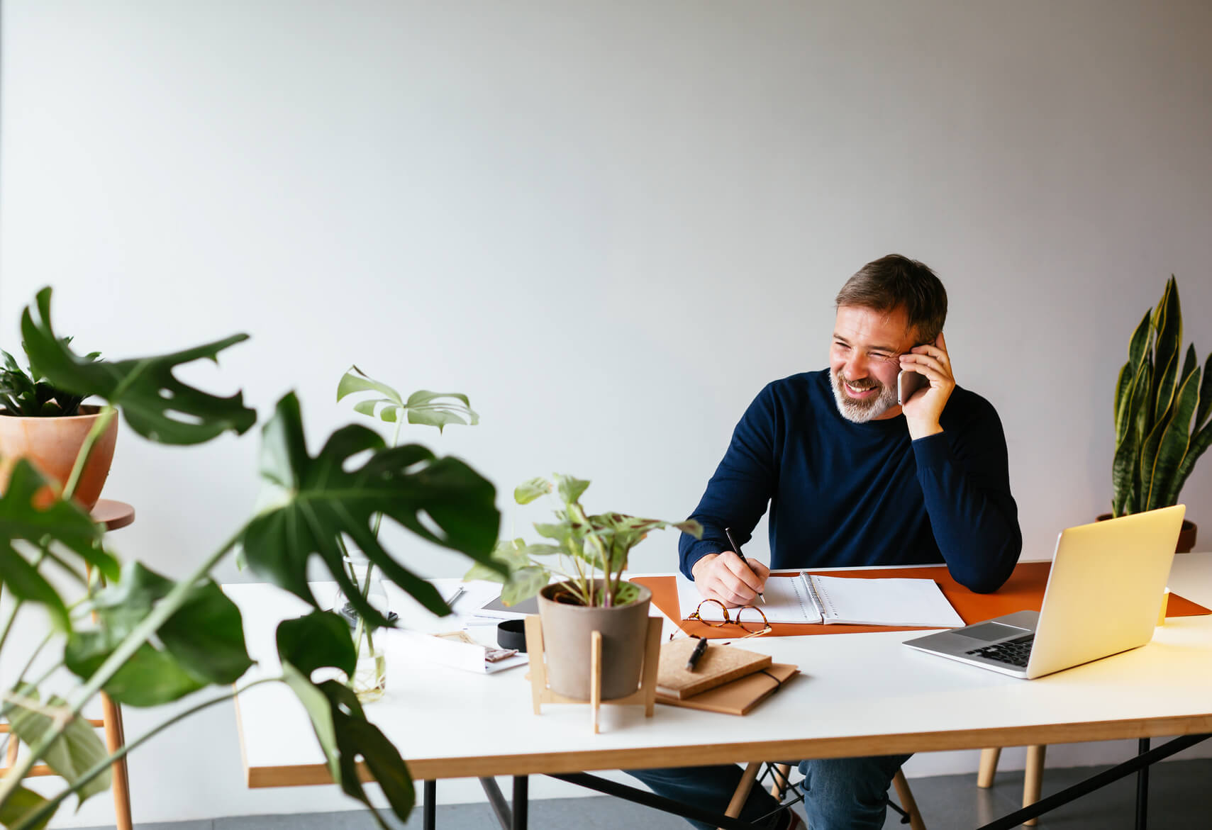 A man using the phone, sitting at his desk.